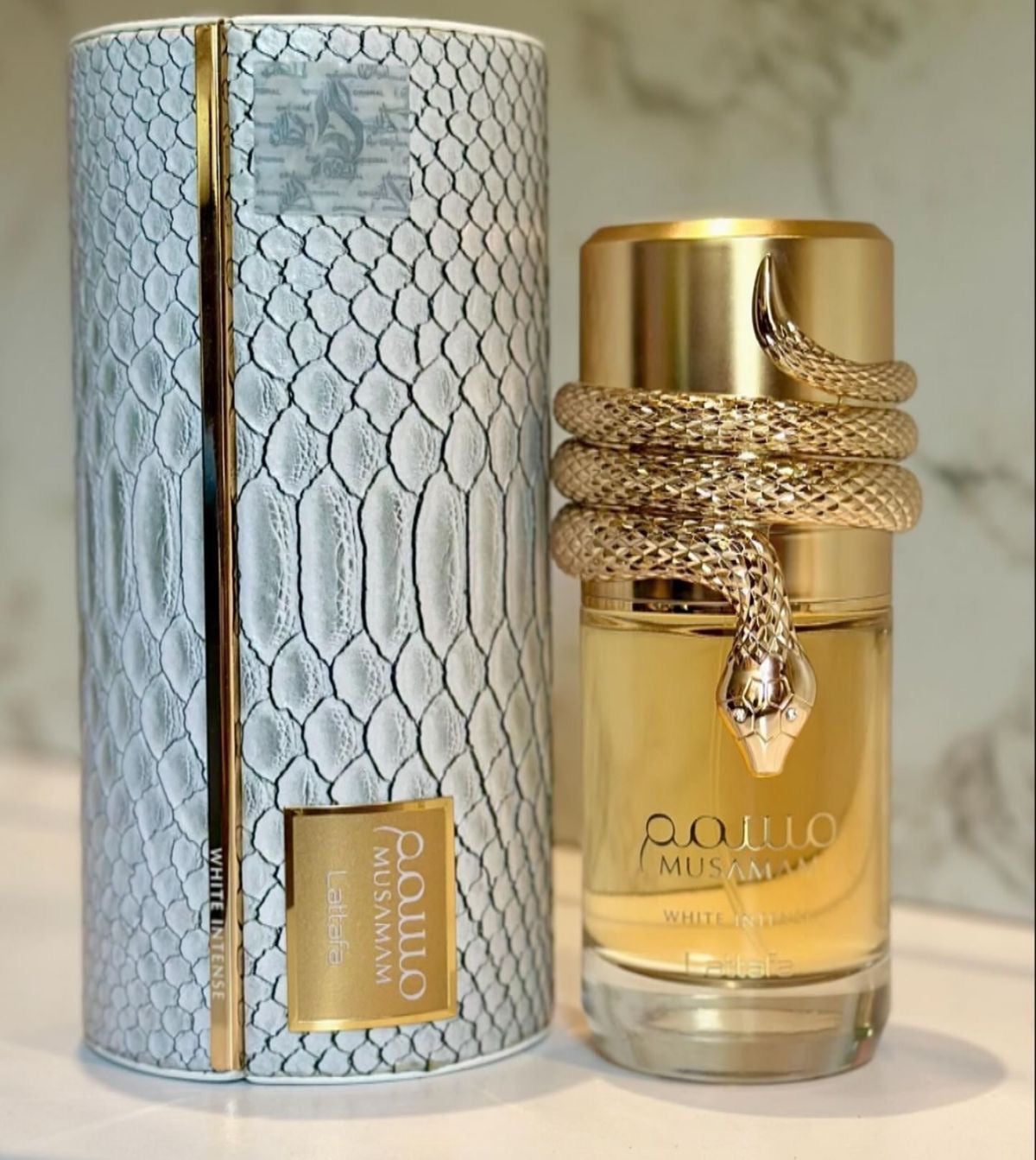 Frasco de perfume feminino musamam white intense lattafa 100 ml dourado com cobra enrolada e nome pouwo musamman