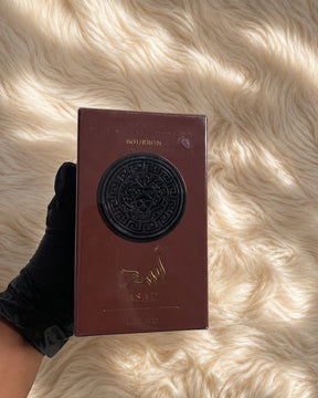 Caixa retangular burgundy com medalhão preto em relevo e letras douradas bourbon perfume asad bourbon lattafa masculino