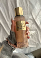 Fragrância corporal bare vanilla shimmer da victoria’s secret em frasco transparente com líquido pêssego cintilante e tampa dourada