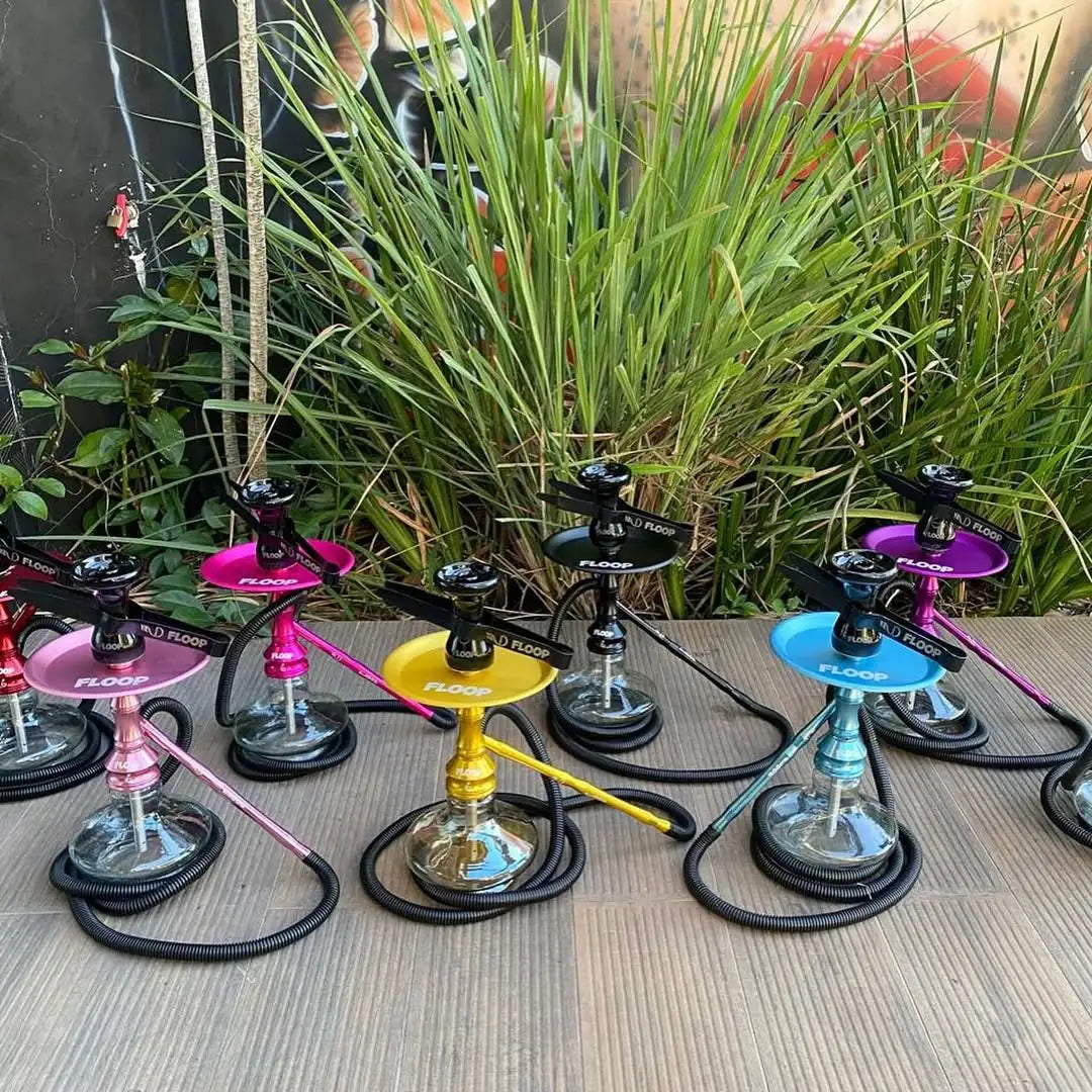 Uma coleção de chapeleiras (hookahs) coloridas com bases metálicas e tampas vibrantes e brilhantes em rosa, dourado, preto, roxo e azul.