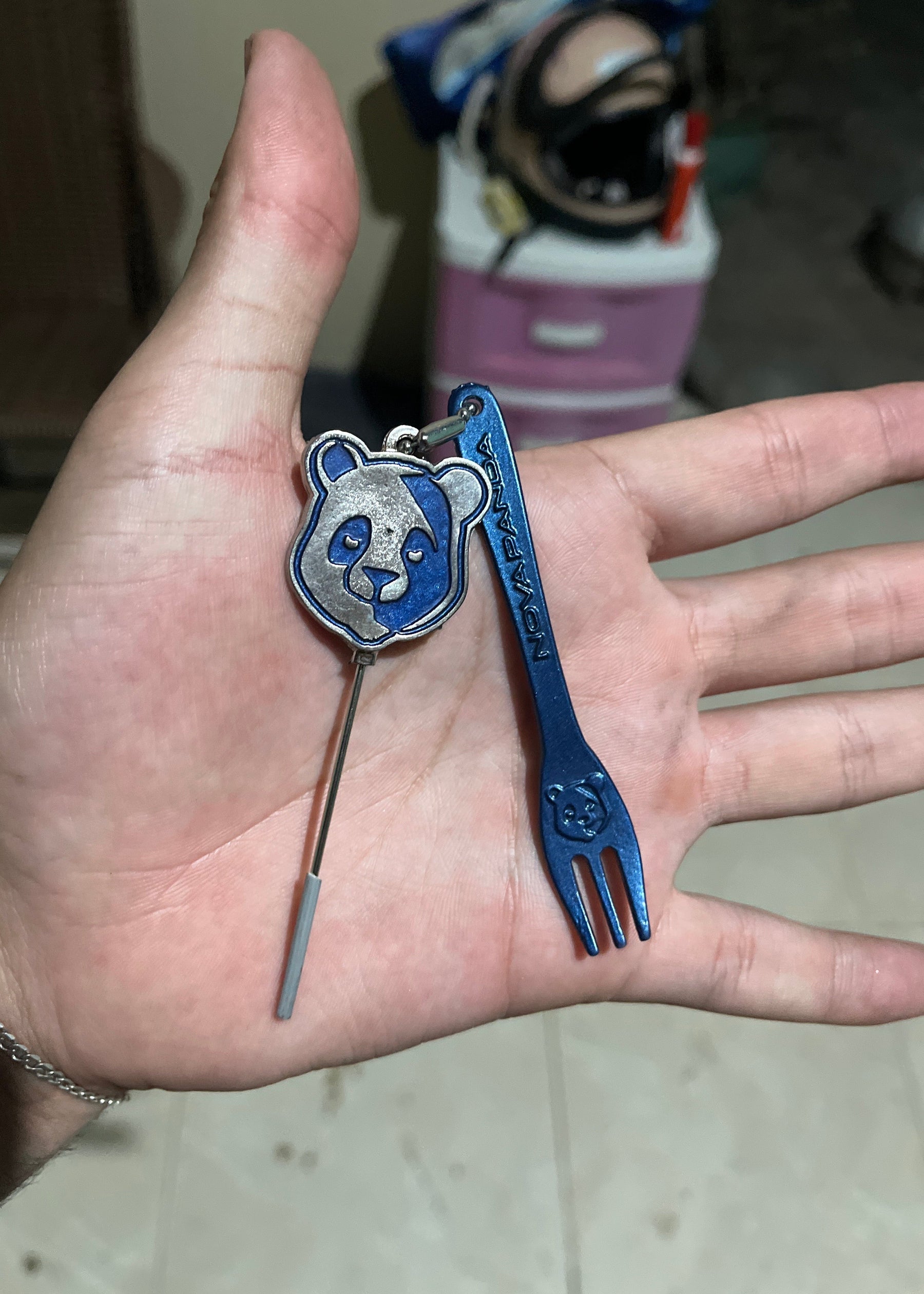 Furador e garfinho de metal azul com tema de panda, detalhes gravados e chaveiro prático para uso diário