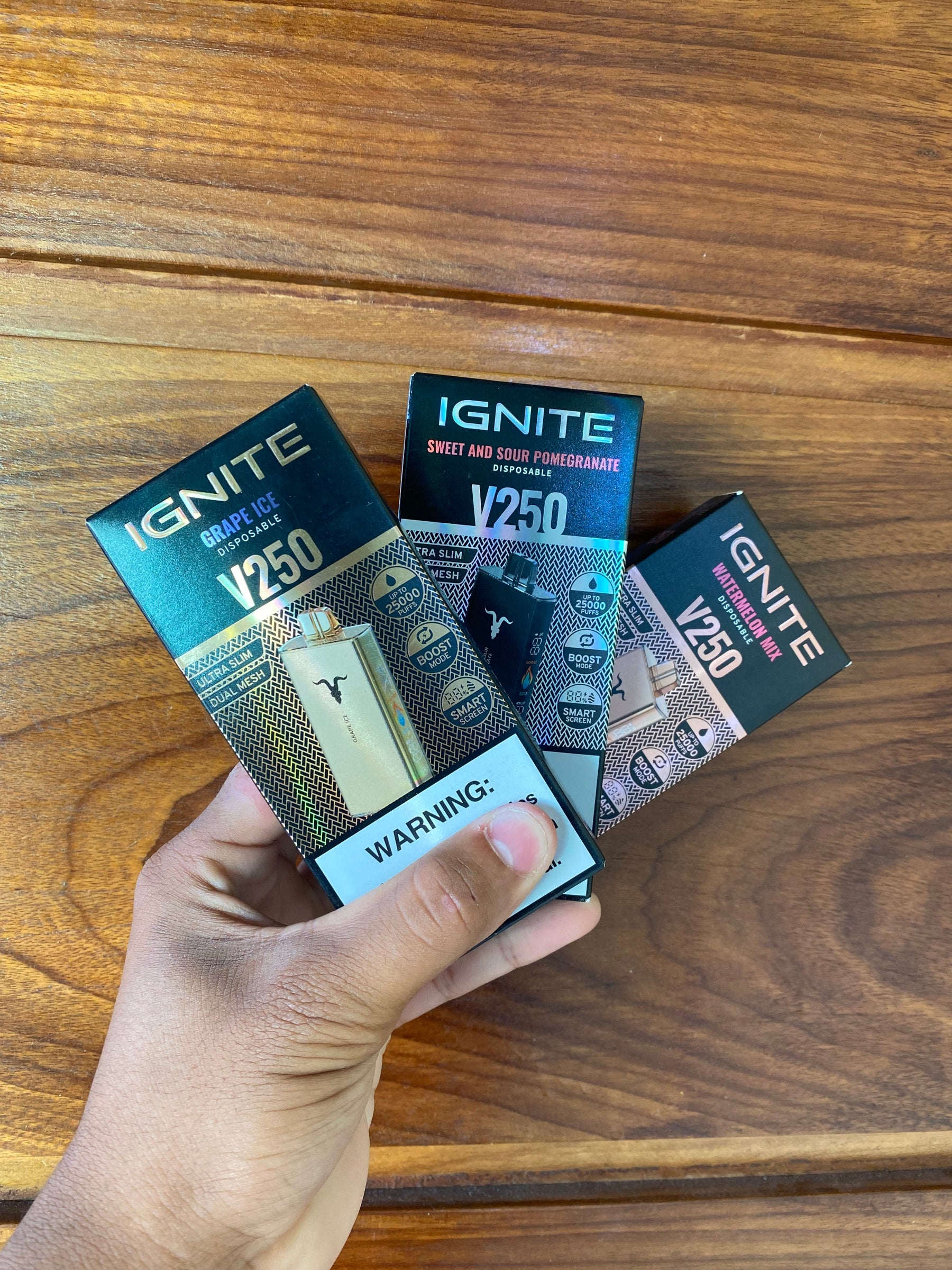 Imagem de três vape descartáveis ignite v250 em embalagem com sabores grape ice e sweet and sour pomegranate