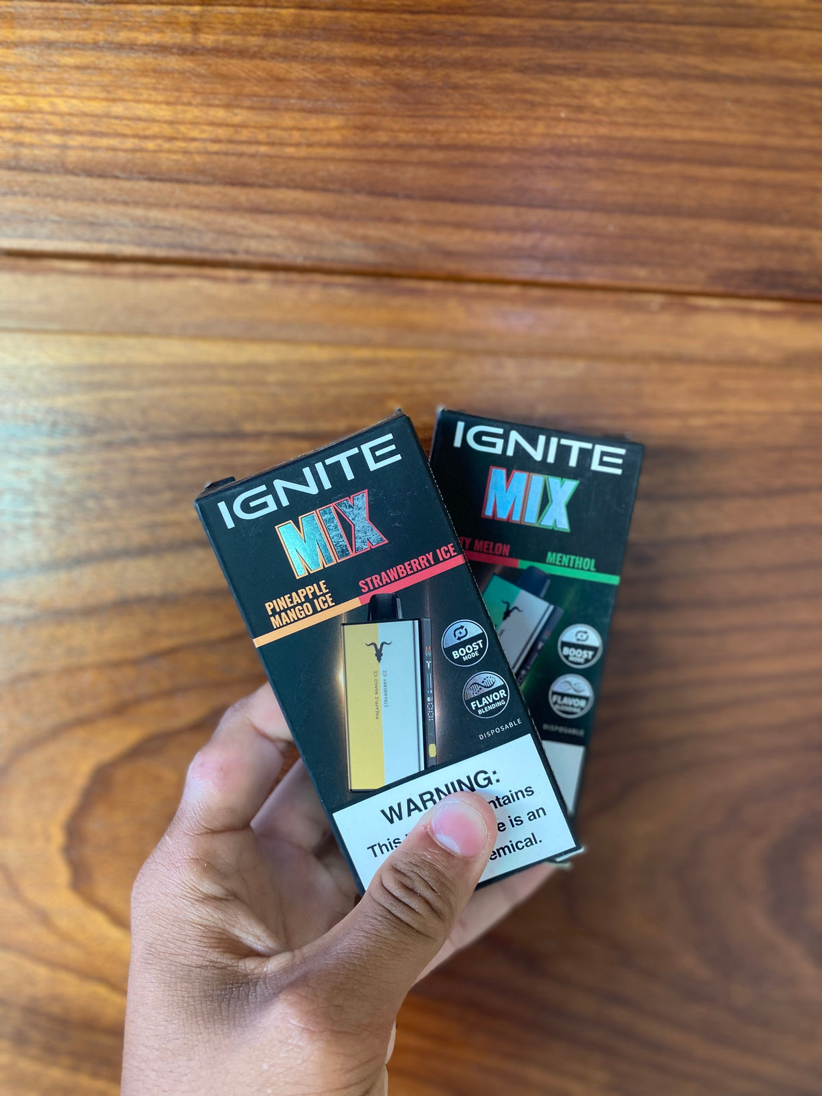 Caixas pretas retangulares de cartuchos de vape ignite v400 mix 5 com rótulos coloridos de sabor e aviso branco na base