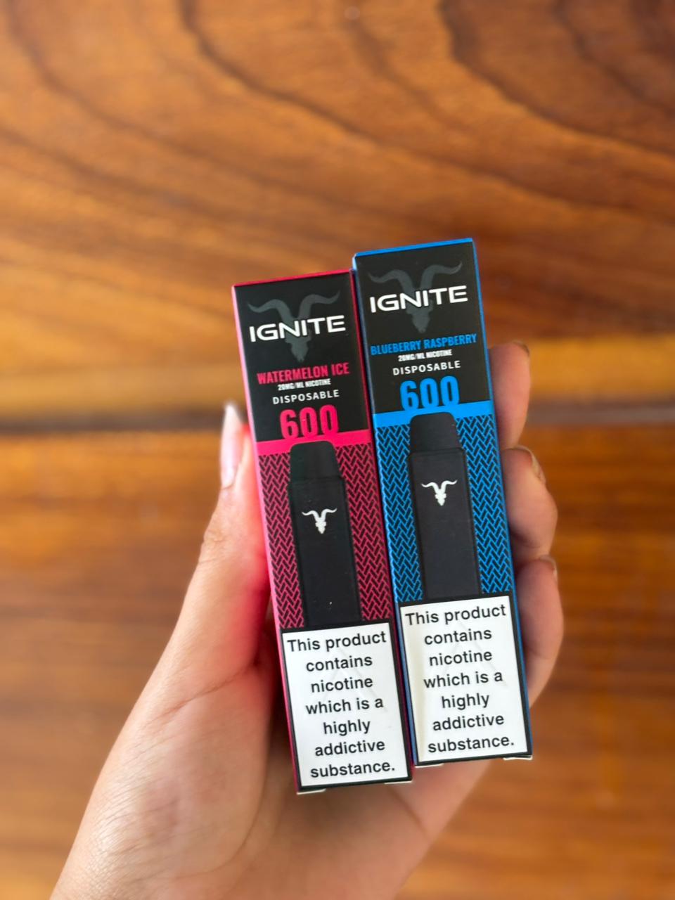 Dois vape descartáveis ignite v600 em embalagens rosa e preta sabor watermelon ice e azul e preta sabor blueberry raspberry