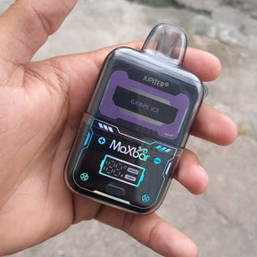 Maxbar jupiter 20k vape pen com display digital roxo e preto mostrando sabor grape ice e iluminação teal ao redor