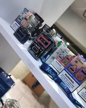 Moxy vape mod preto e rosa com tanque transparente exibido em prateleira branca maxbar jupiter 20k com 1 cartucho extra