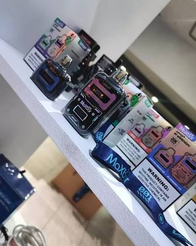 Moxy vape mod preto e rosa com tanque transparente exibido em prateleira branca maxbar jupiter 20k com 1 cartucho extra
