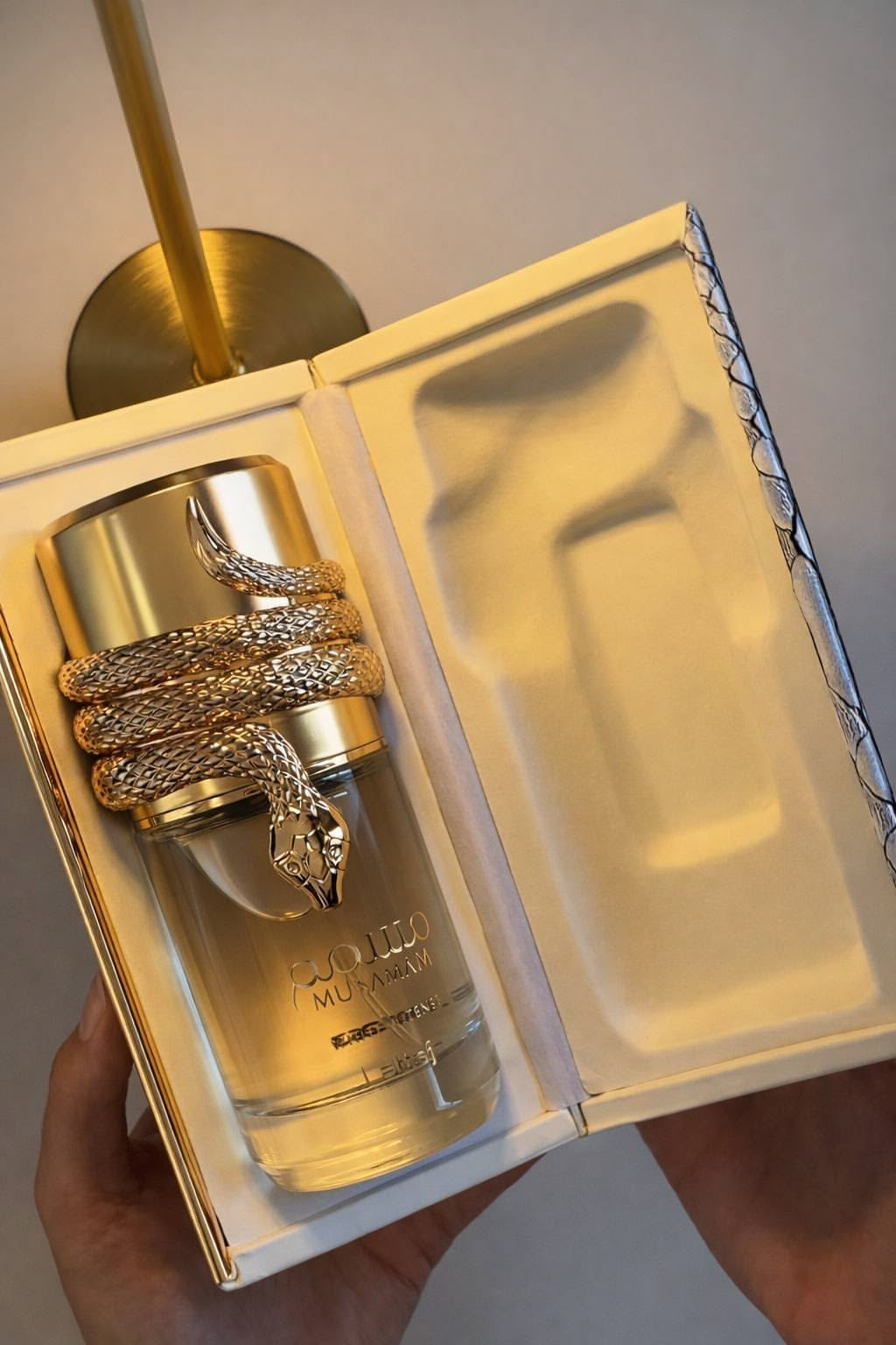 Frasco de perfume feminino musamam white intense lattafa 100 ml dourado com cobra em relevo e acabamento metálico texturizado