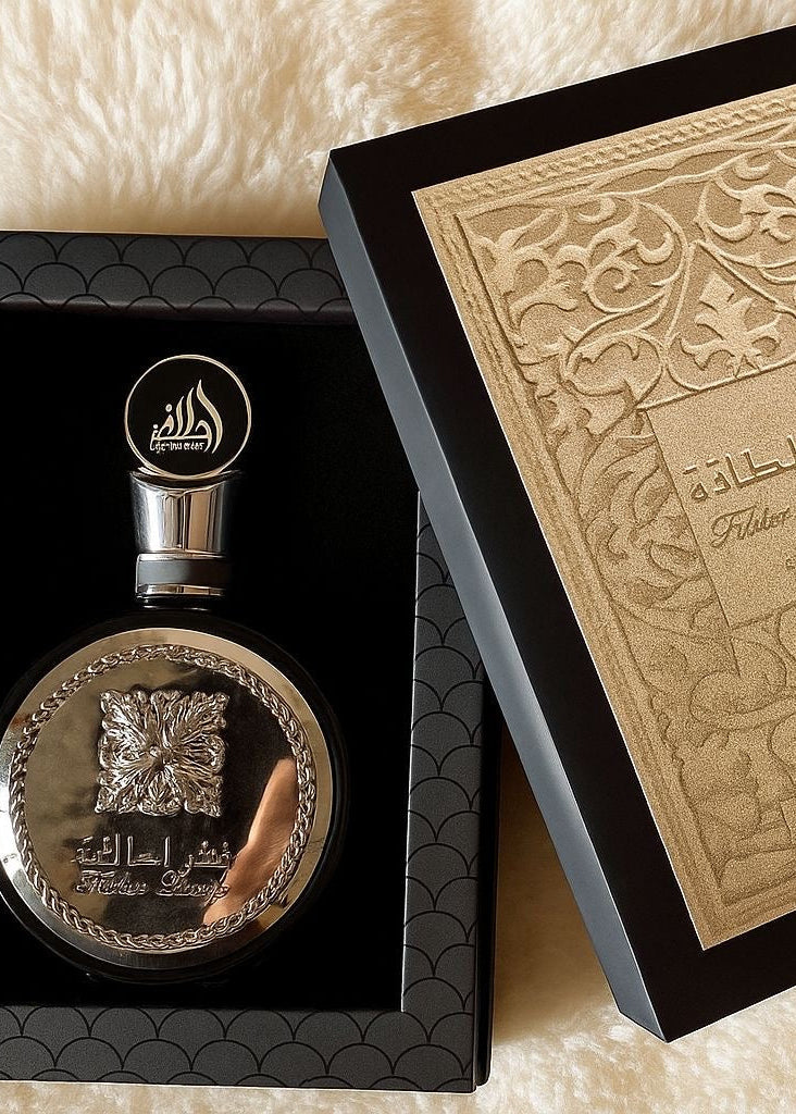 Elegante perfume fakhar black lattafa eau de parfum masculino em frasco prateado com gravação floral e escrita árabe em caixa preta luxuosa