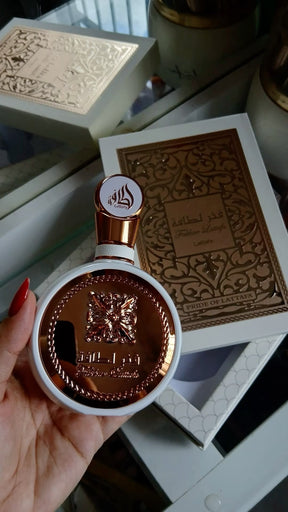 Frasco de perfume lattafa fakhar rose eau de parfum 100 ml em rosa dourado e branco com design ornamentado e em relevo