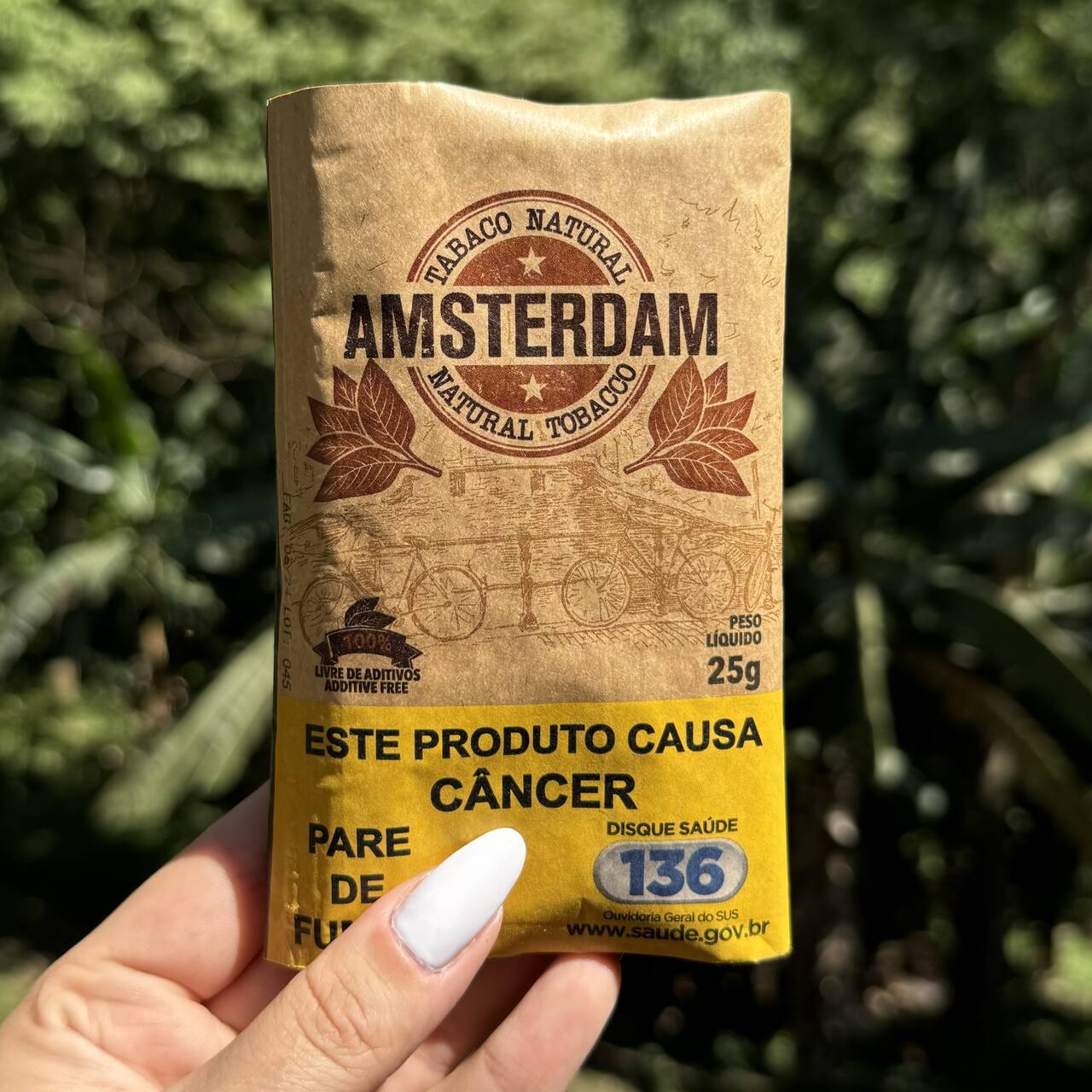 Pacote marrom de tabaco natural amsterdam 25g com design vintage e etiqueta amarela de advertência