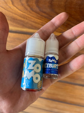 Duas garrafas de zomo nic salt 30ml 50mg de e-líquido com sabores pineapple ice e iceburgs em rótulos azuis e brancos