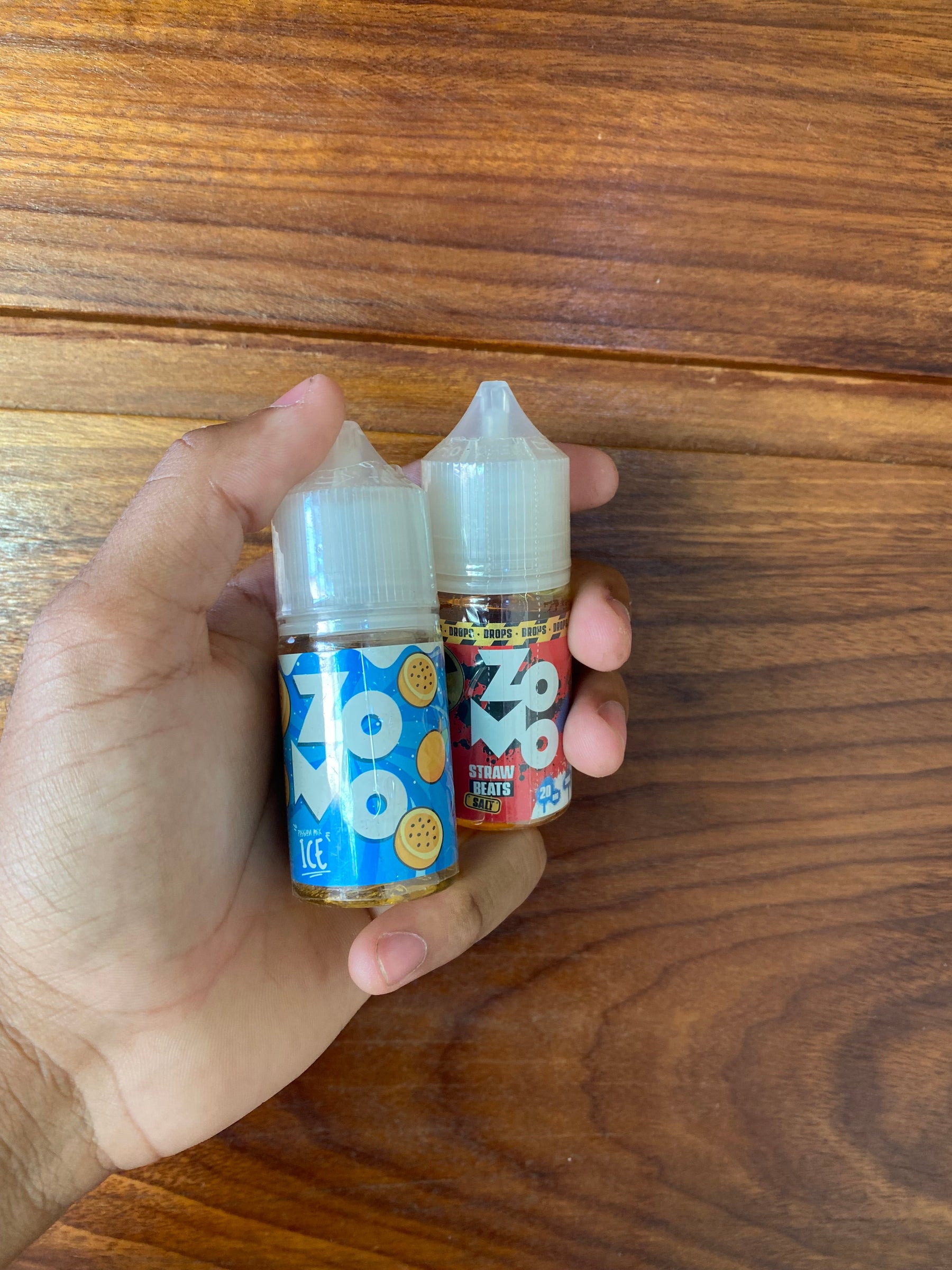 Duas garrafas de e-liquido zozo nic salt 30ml 50mg uma com rotulo azul sabor cookie e outra vermelha strawberry hearts